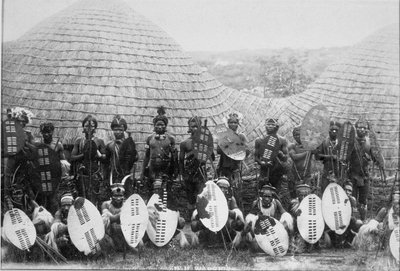 Group Portrait of Zulu Warriors outside a hut, c.1875 by English Photographer